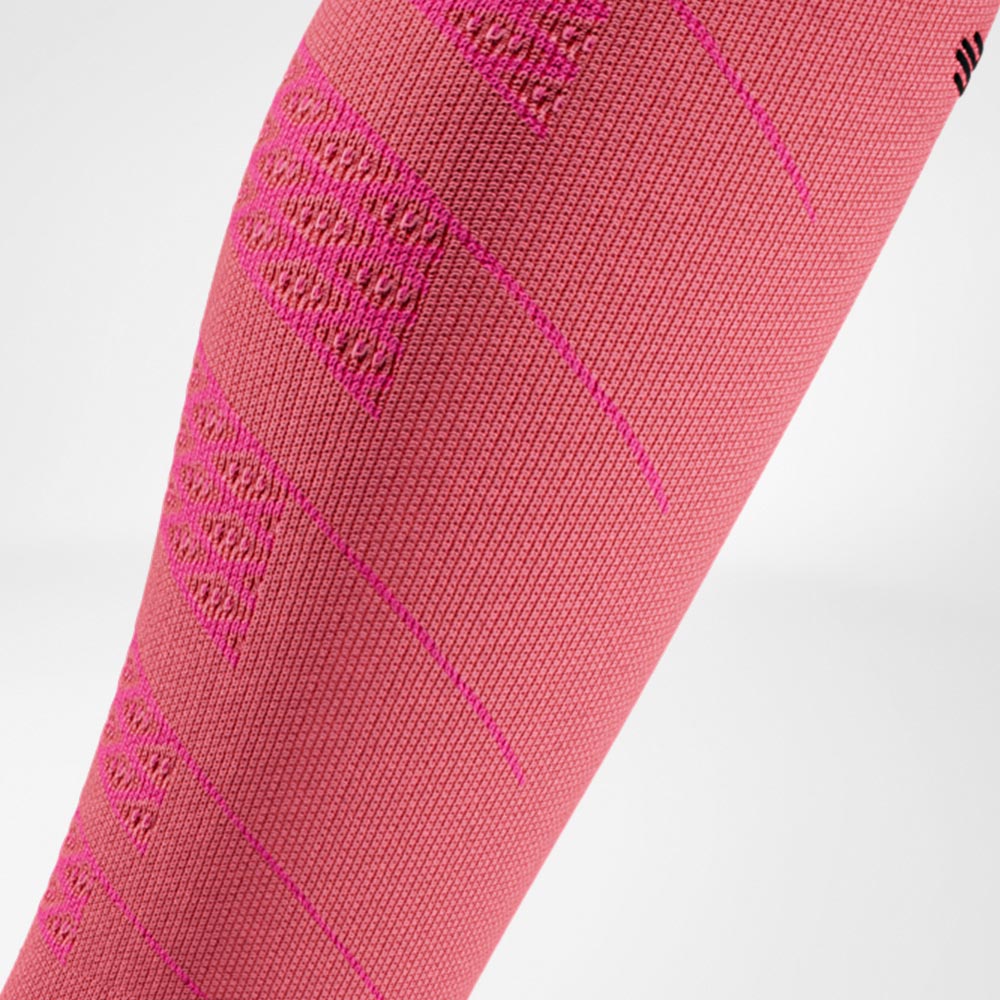 Close-up of a pink compression sleeve for runners, showing the knitted structure that delivers targeted compression and calf muscle support.