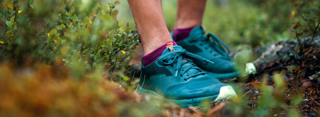View from the forest floor on the feet of a runner with short running socks