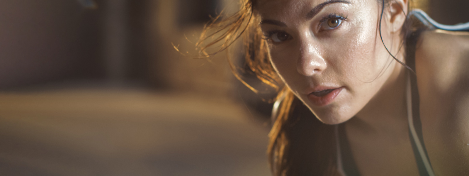 Sporty woman looks a bit sweaty from the right to the viewer