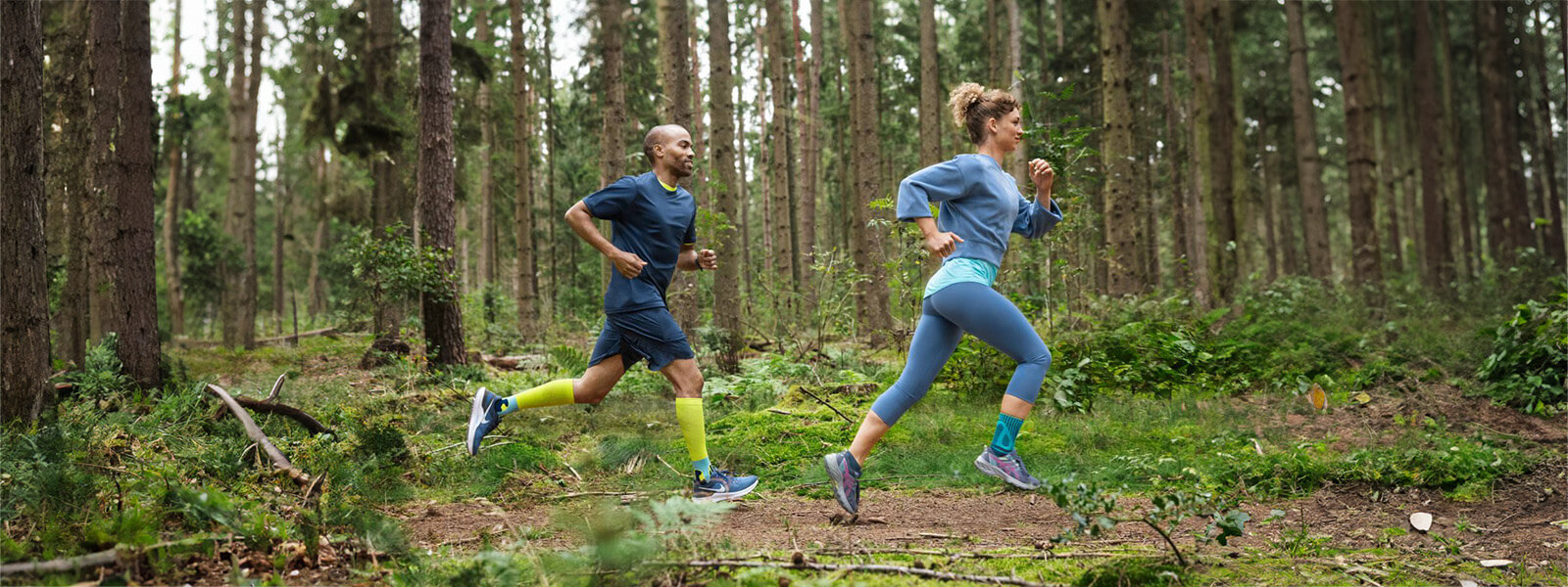 A woman and a man are running through the forest A woman and a man are running through a dense forest, wearing bandages