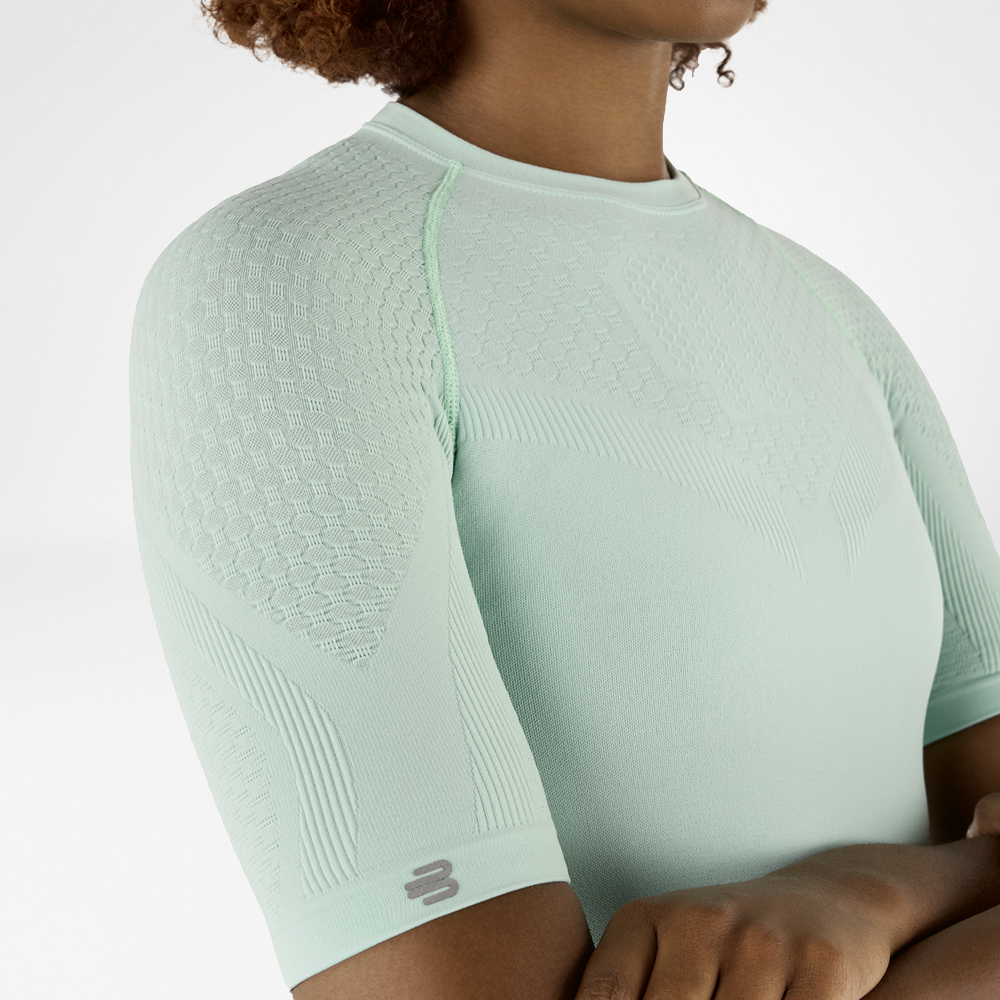 Side close-up of a mint green compression shirt with detailed textured fabric on the shoulder and arm.