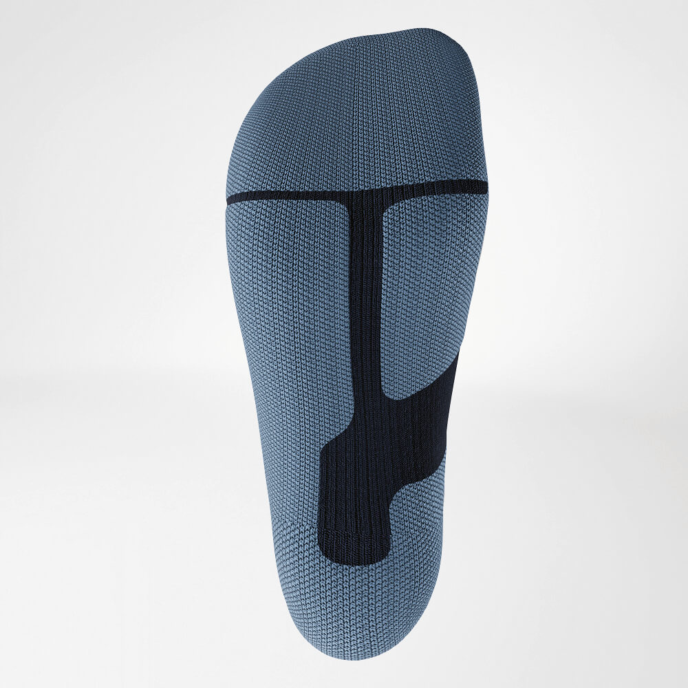 Close-up of the sole of a blue ski compression sock, featuring an ergonomic knit pattern for stability and cushioning. Designed for maximum comfort during intense sports activities.