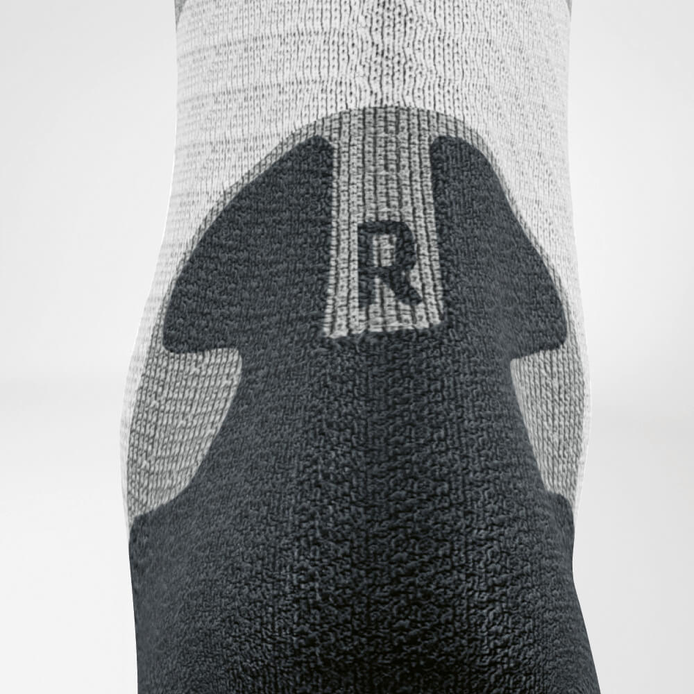 Detailed view of the Achilles' area of ​​the gray -white trail run - running socks