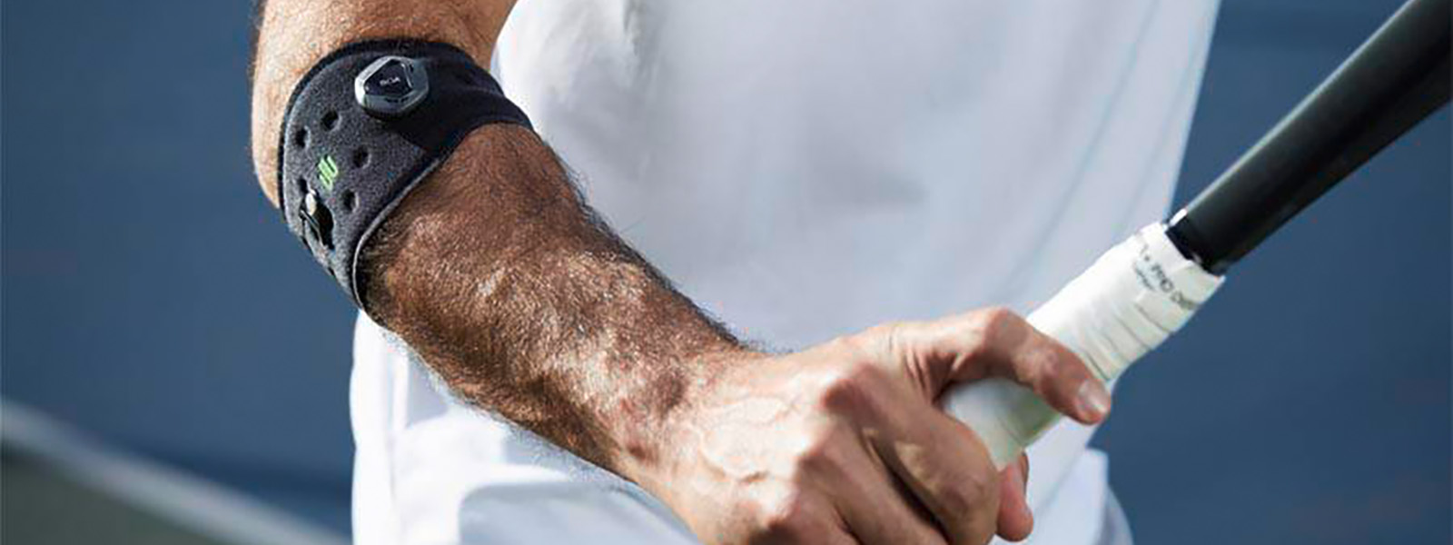 Tennis player with an elbow bandage has tennis racket in hand