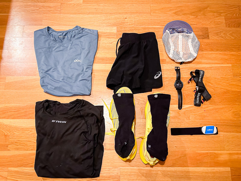 Half marathon preparations: A complete race day outfit, including blue running gear, yellow running shoes, and technical accessories like a heart rate monitor and running watch, is laid out and ready.