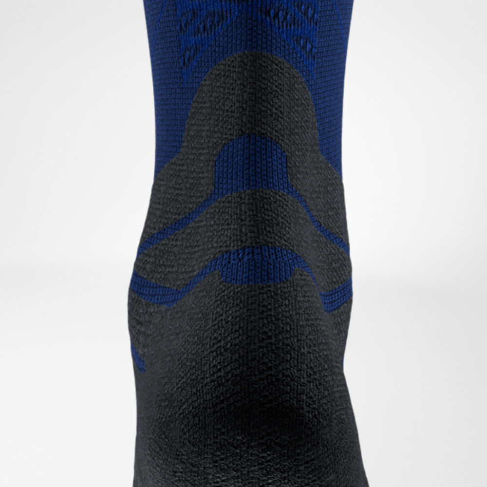 Close-up of a blue and black running sock by Bauerfeind Sports, back view at the Achilles tendon area. The distinctive padding protects the tendon from friction inside the shoe.