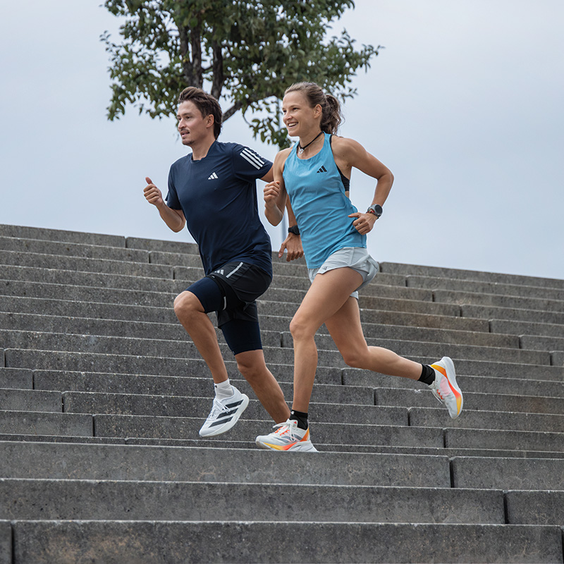 Two runners and a runner run a tram line in a city