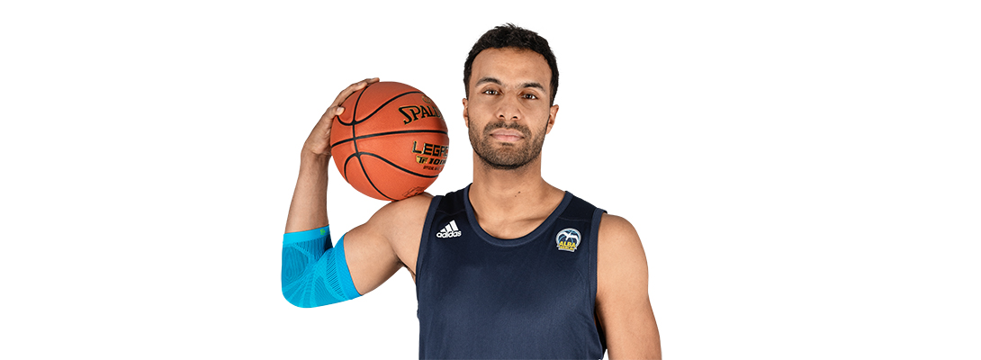Man with basketball wears a sports leeve for the elbow