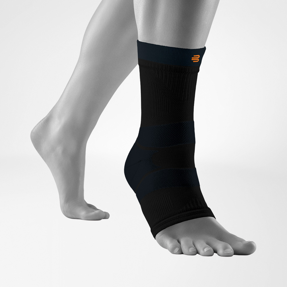 Isolated view of the black Outdoor Compression Ankle Support worn on a model’s foot. The ankle support fits snugly and highlights the anatomical shape and structured compression zones designed to stabilize the ankle during hiking activities.