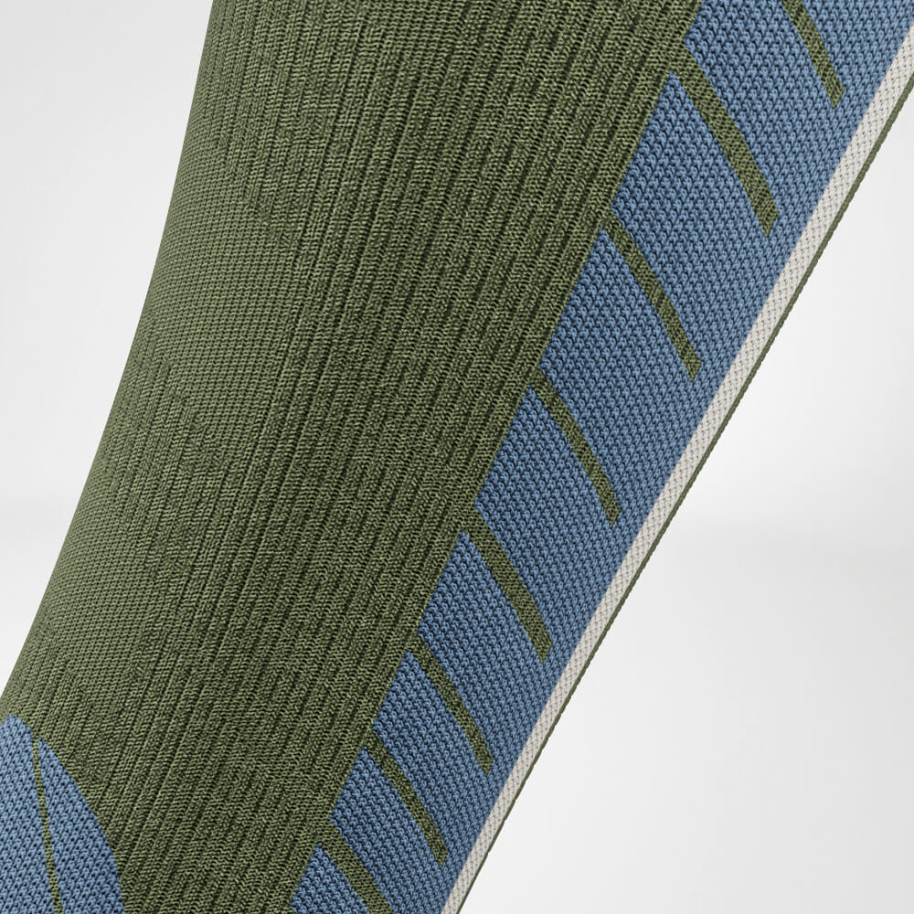 Close-up of the calf of a green ski compression sock with precise knit pattern, ensuring breathability and optimal comfort. Perfect for intensive winter sports activities.