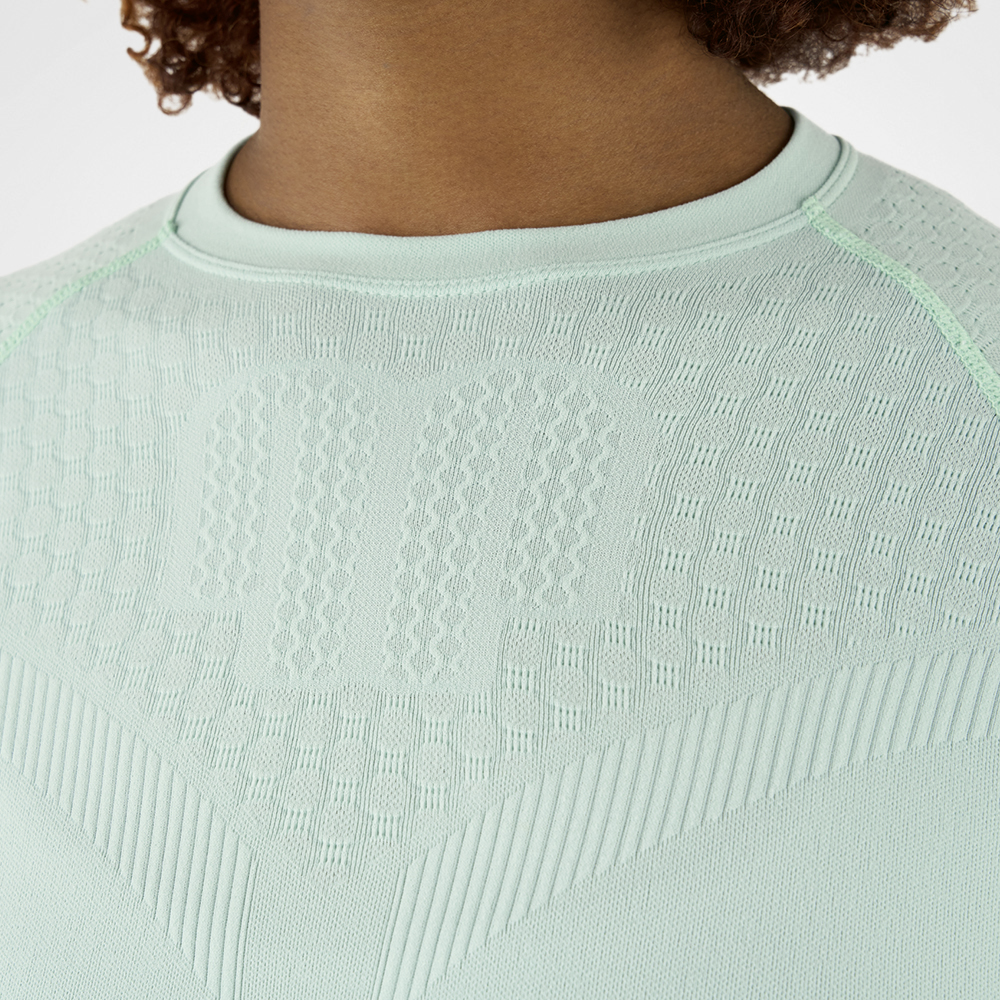 Close-up of a mint green compression shirt with textured fabric, highlighting the texture and details of the material.