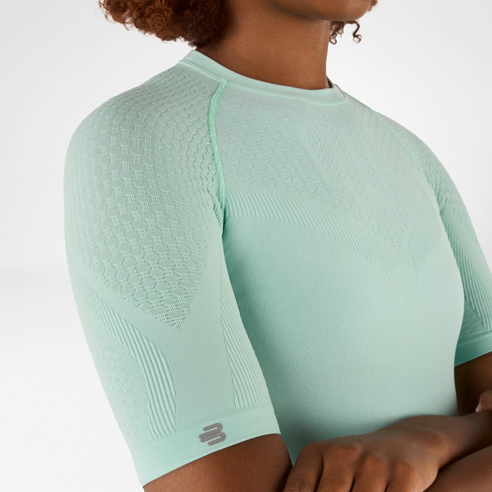Side close-up of a mint green compression shirt with detailed textured fabric on the shoulder and arm.
