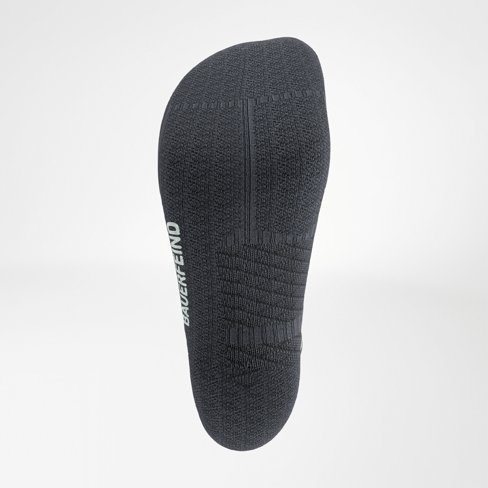 View of the underside of a dark grey Bauerfeind Run Performance Midcut Sock with slip-resistant knit structures and white logo on the sole.