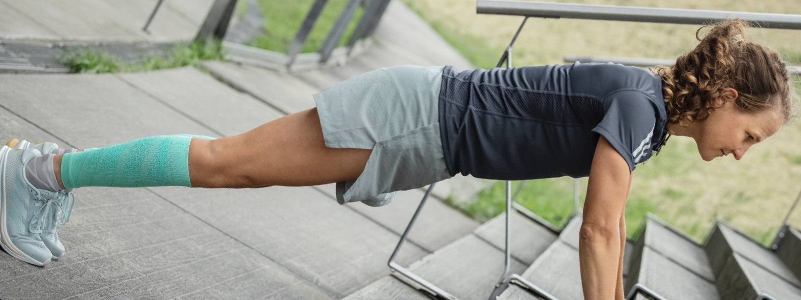 Woman puts push-ups on a concrete floor view of diagonal