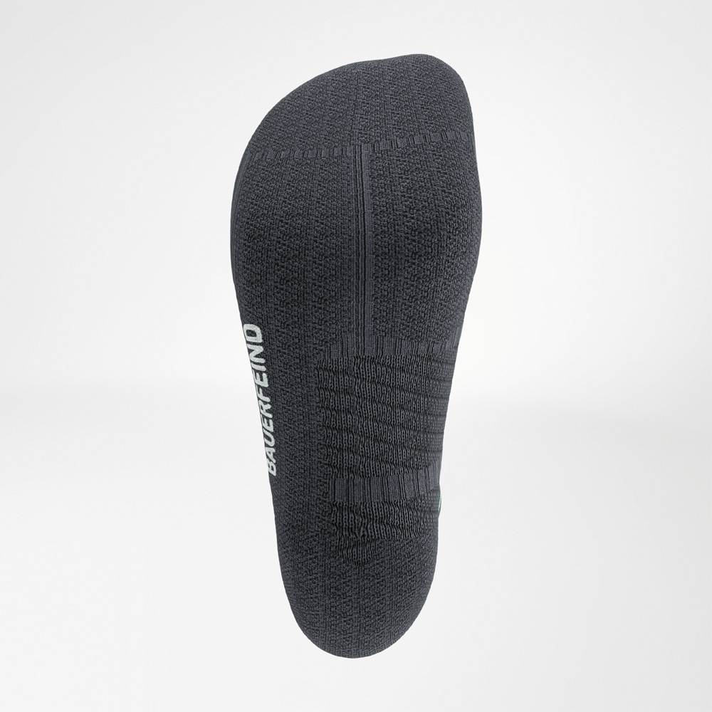 Detailed view of the sole of a black Run Performance Midcut Sock. The woven Bauerfeind logo is visible on the side, and the knit structure provides grip and targeted cushioning.