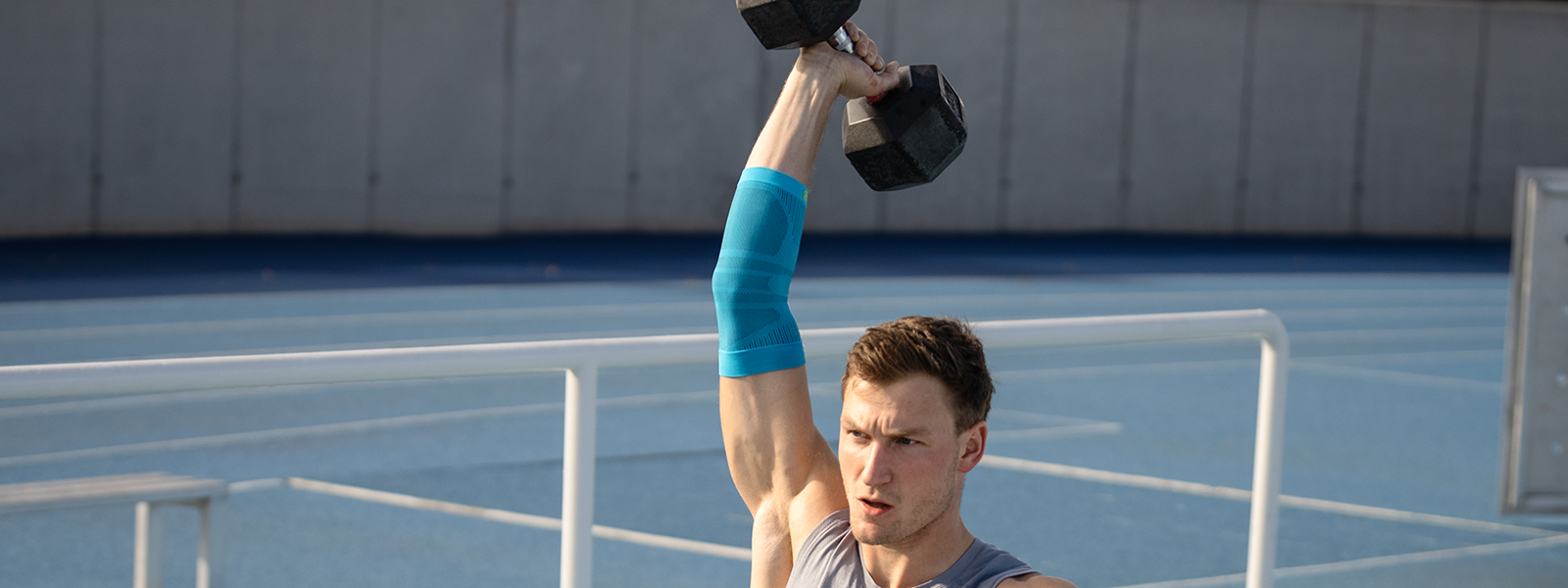 Thoms Röhler holds up a weight and stabilizes its arm using a elbow bandage