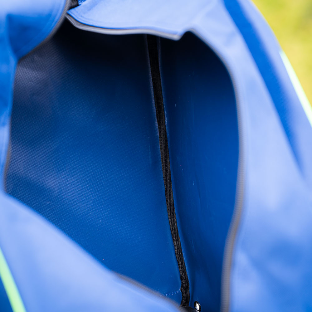 A close-up of the interior of a blue bag with a black zipper. The interior is empty, and the fabric details are visible.