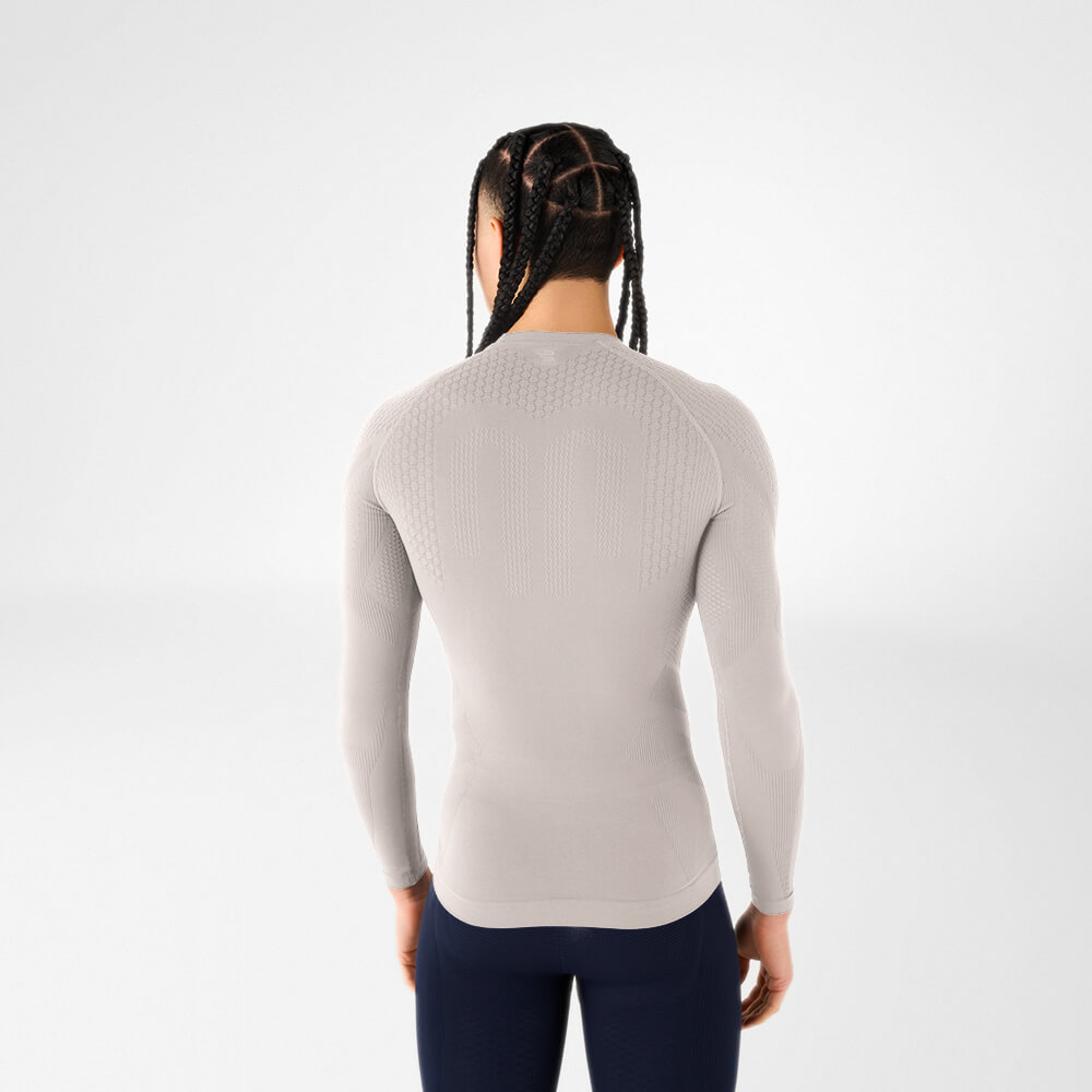 Feel the difference – Our compression shirt drives your performance forward Rear view of a man wearing a silver-grey long-sleeve compression shirt with a structured back and woven pattern for breathability and muscle support.