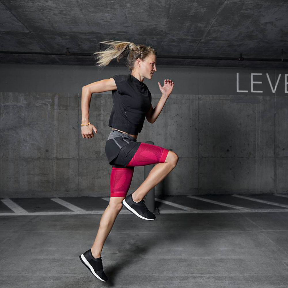 Thigh Sleeves while running on the street Woman runs through an underground car park with pink thighs and does sports