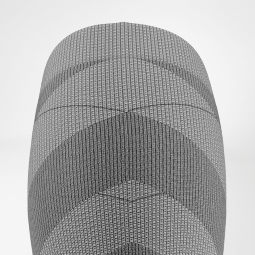 Precision pressure – targeted compression to the knee Top-down detail view of the upper part of the women's ski compression sock featuring ribbed structure and graduated compression zones around the knee.