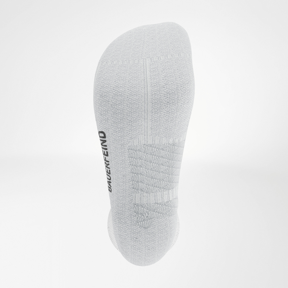 Close-up of the sole of the white Bauerfeind Run Performance Socks, showing padding and knitted BAUERFEIND logo.
