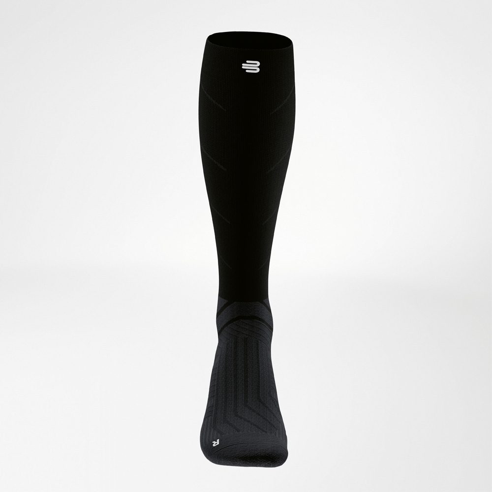 Frontal view of a black long compression sock with continuous structure to support foot and lower leg during training.