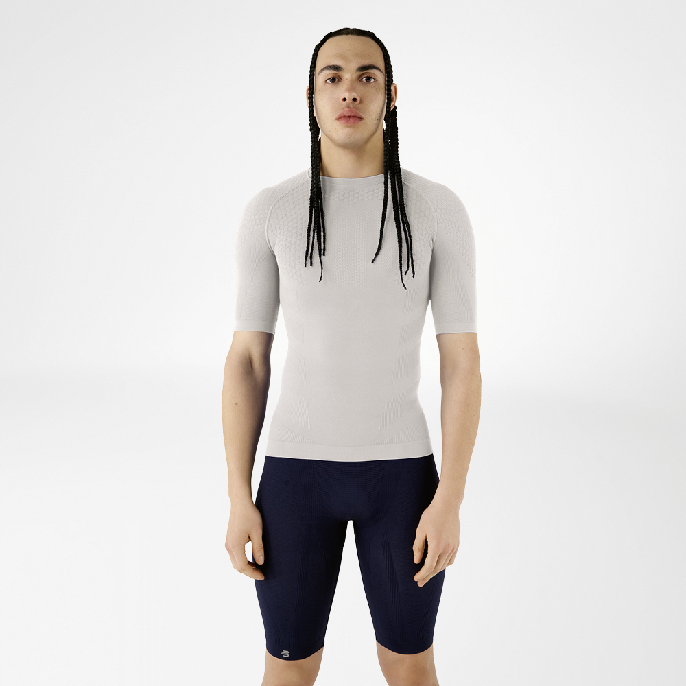 A man in silver-grey compression wear standing upright and looking at the camera.