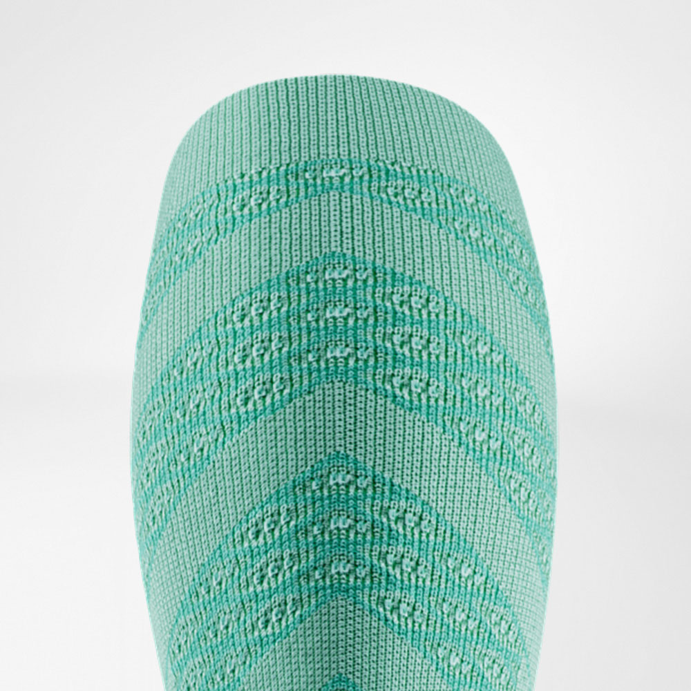 Close-up of a light green compression sleeve with fine V-shaped knit structure. The design looks fresh and lightweight, perfect for summer runs and long sessions with maximum comfort.