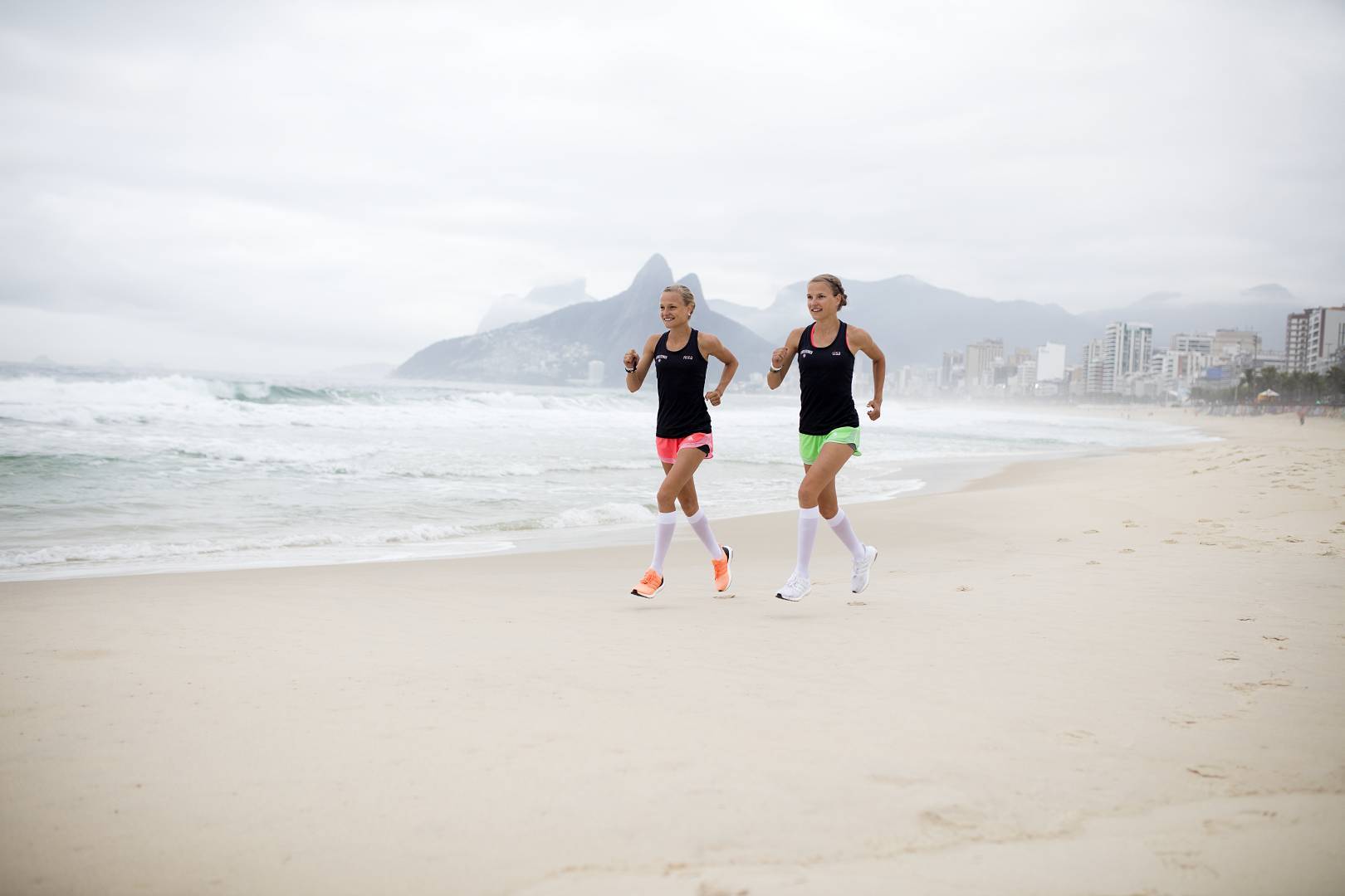 Twins run on the beach of Rio with white running socks