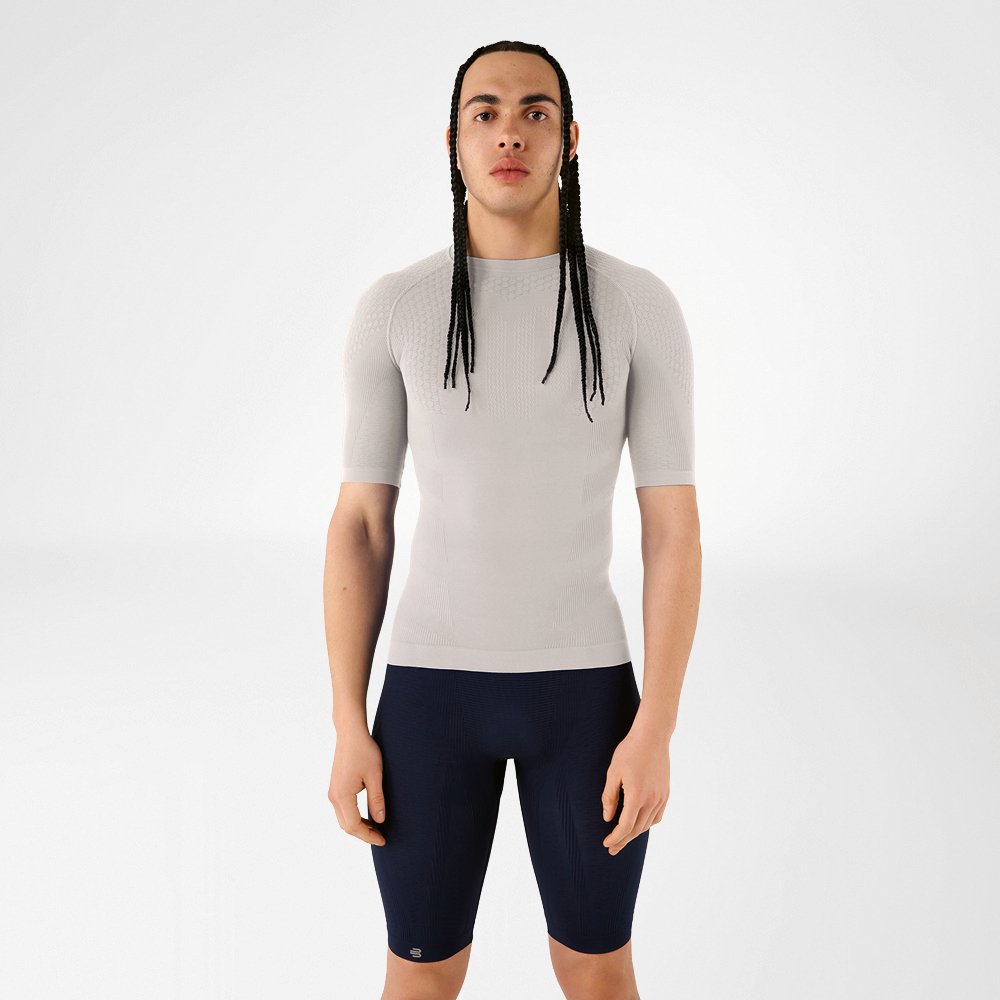 A man in silver-grey compression wear standing upright and looking at the camera.