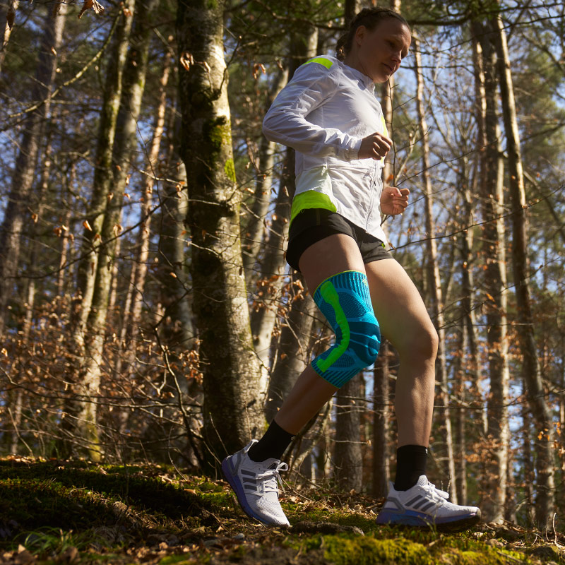 Anna Hahner runs down the forest path with a knee band