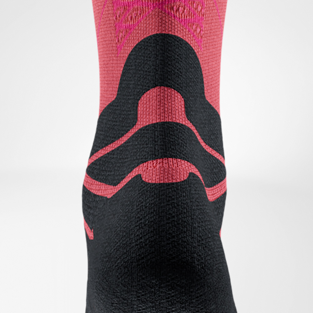 Close-up of a red running sock with a black lower section. The ribbed structure and reinforced Achilles tendon area are clearly visible.