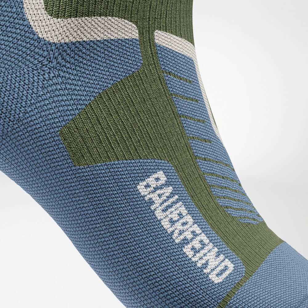 Close-up of the instep of a green ski compression sock with reinforced, ergonomic knit design. Provides optimal support and pressure distribution for maximum comfort during intense sports activities.