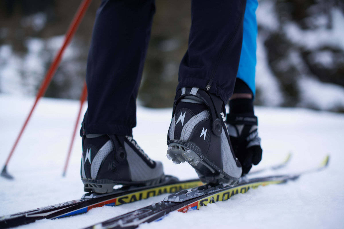 A cross-country skier buckles his shoes to the skis close-up