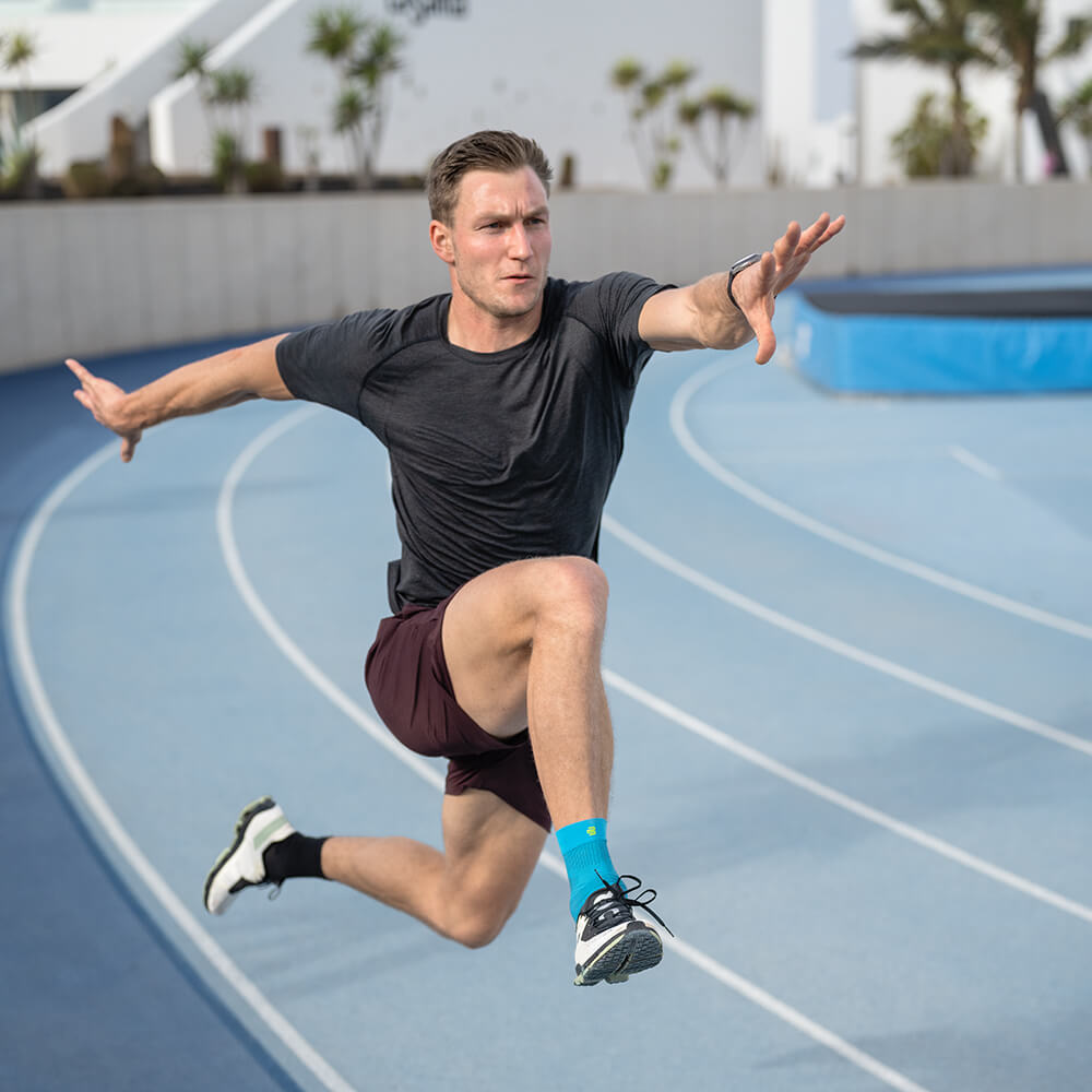 Ankle bandage in hurdle jumping Runner with compression ankle support in hurdle jumping