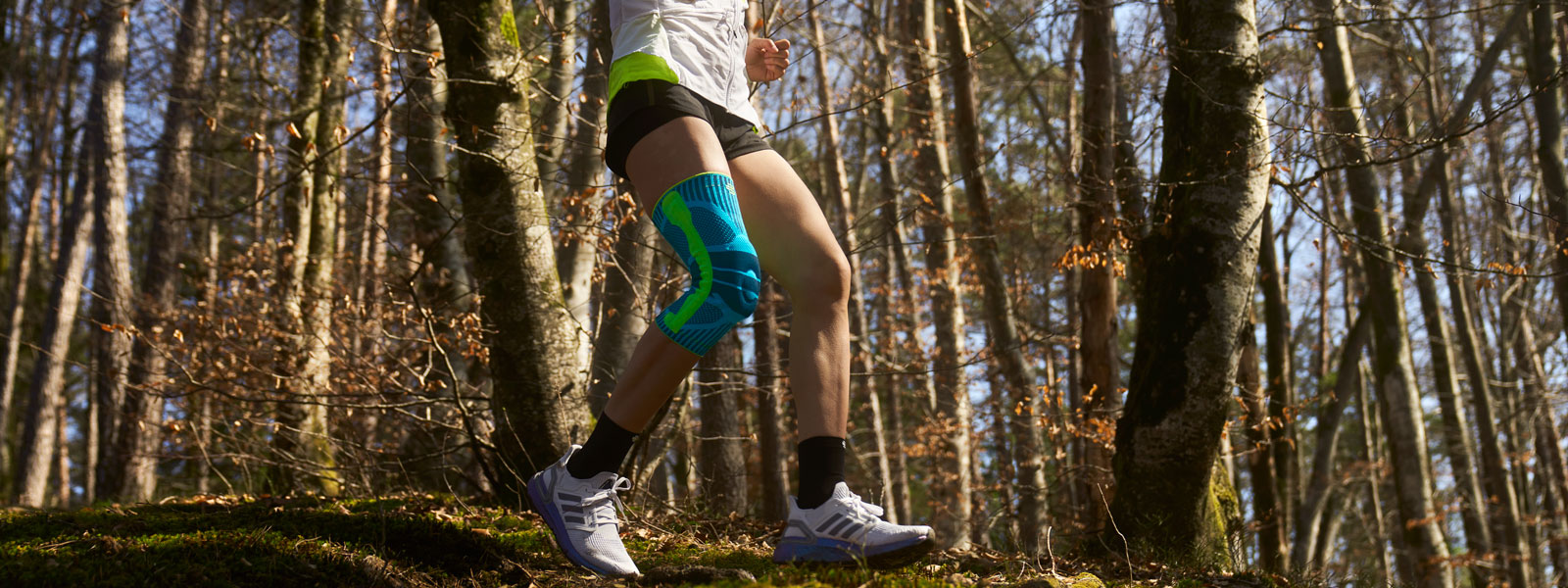 Anna Hahner runs down the forest path with a knee band