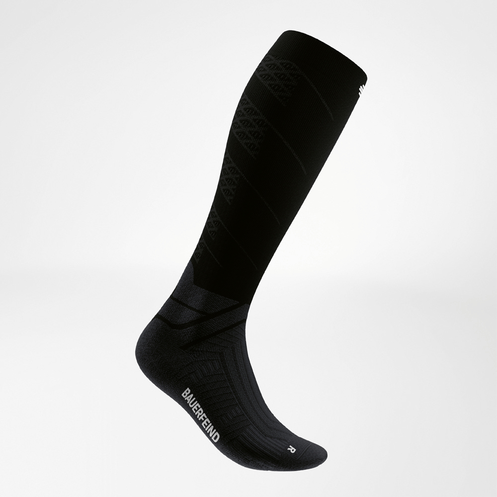 Side support structure at instep and ankle Side close-up of a black compression sock with structured support at the instep and ankle for increased stability.