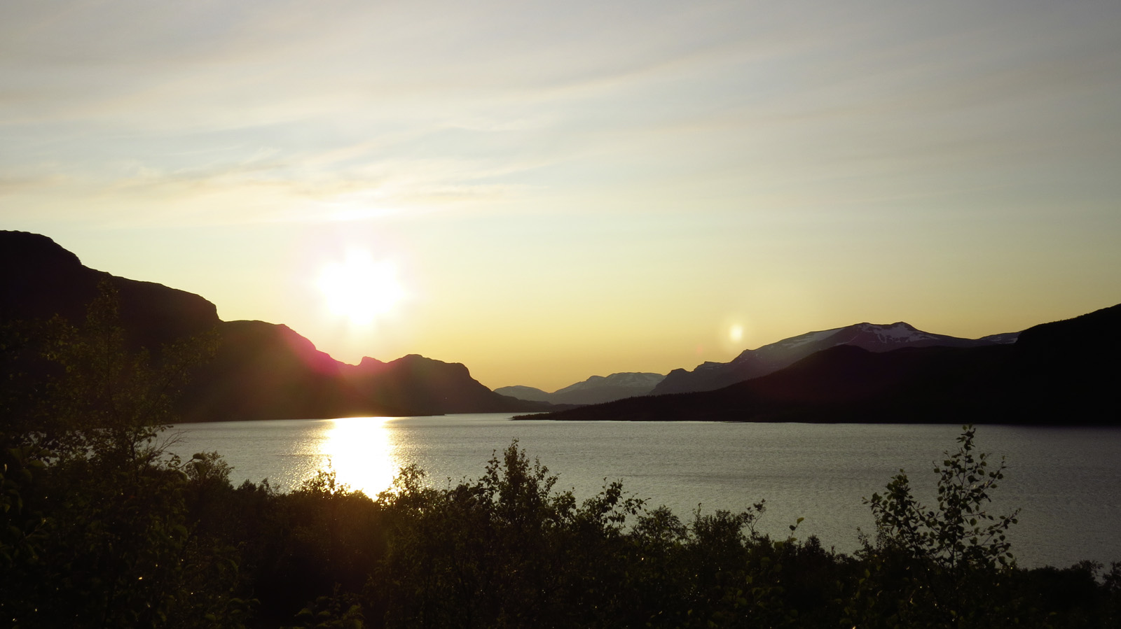 Panorama of a lake with mountains at sunset