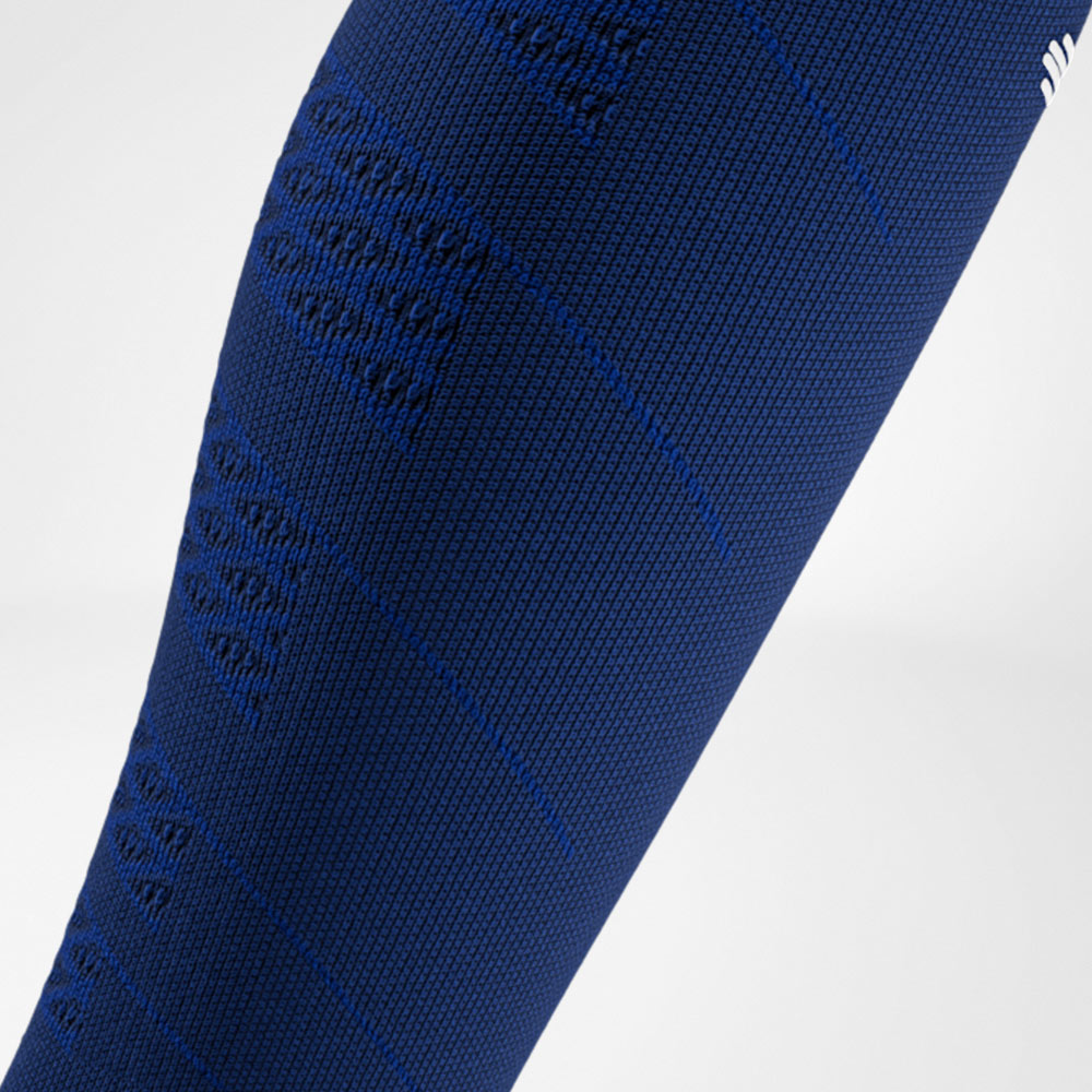 Close-up of a navy blue compression sleeve with fine texture and integrated compression zones along the calf.