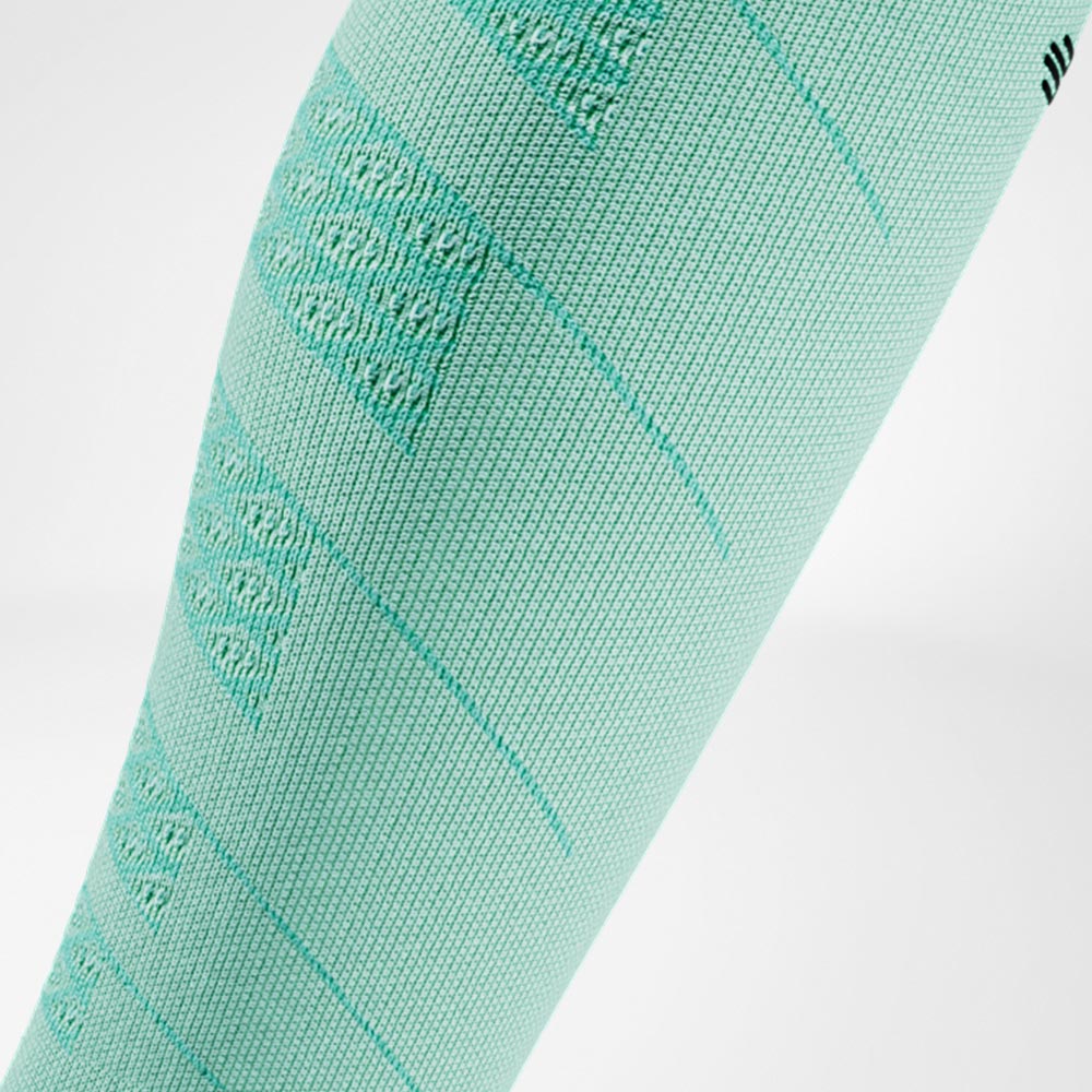 Close-up of a mint green Run Performance Compression Sleeve on the lower leg, with a breathable knit structure that ensures light and comfortable compression.