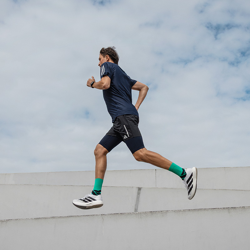 Man runs in a city next to a modern museum