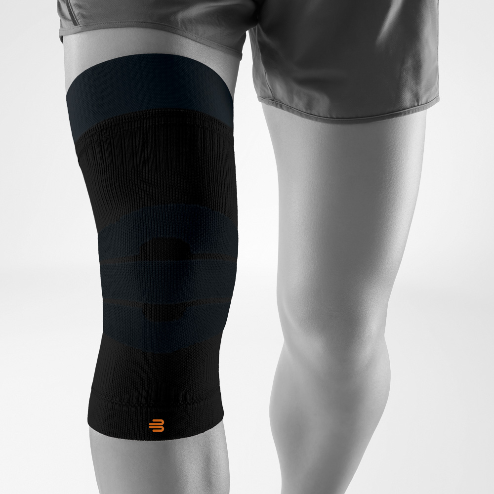 Black knee support for outdoor activities, worn on the leg, providing targeted compression and stability during sports and outdoor movement.