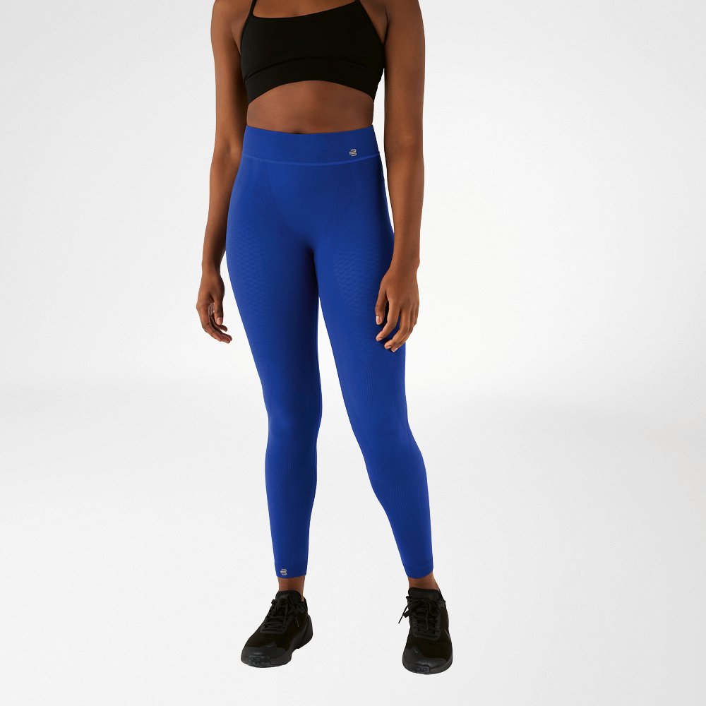 A woman in a black sports bra and navy blue, ankle-length high-waisted sports tights