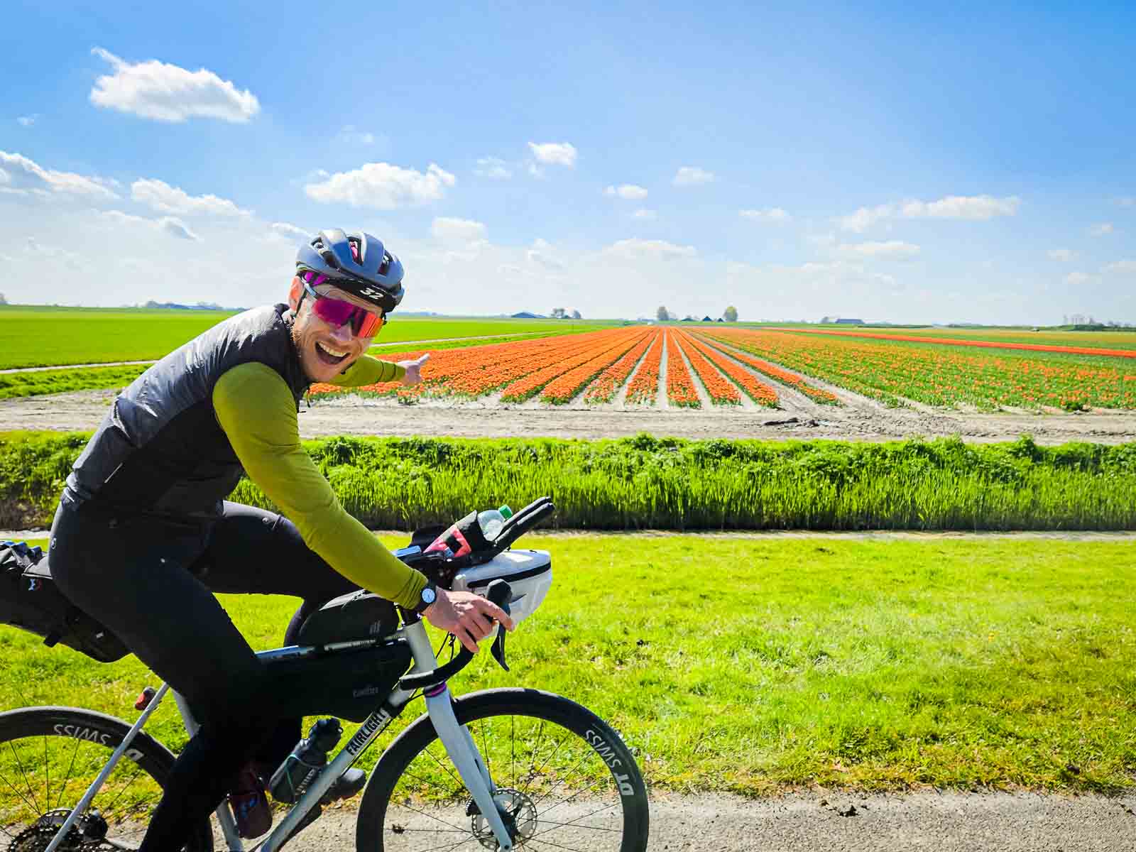 A participant in the Race arouund the Netherlands enjoys the sight of colorful flowers and points to them