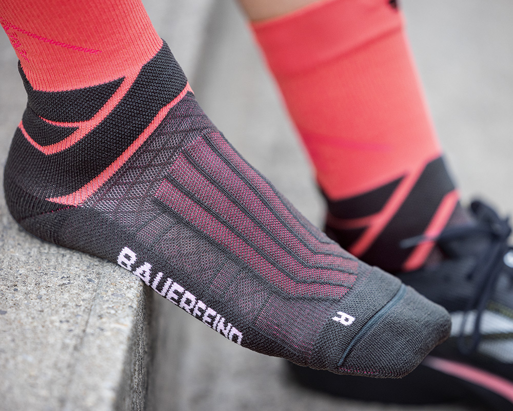 Man with gray-blue running socks laced his running shoes