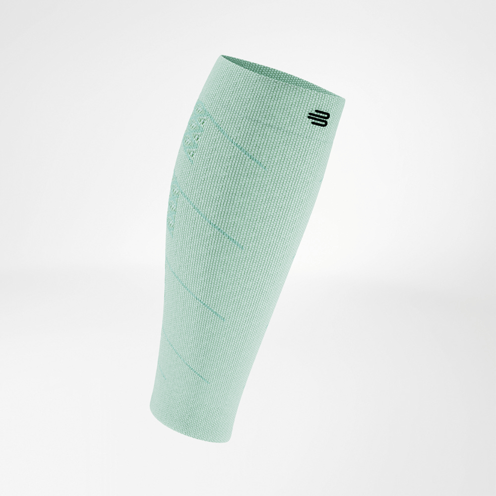 Light green compression sleeve in angled side view, with a black logo near the top. The lightweight, breathable fabric wraps tightly around the lower leg with fine knit structures.