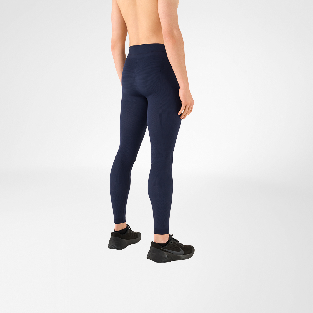 Compression and sports trousers for men You can see a detail of a shirtless man wearing black sports shoes and anthracite grey compression trousers. He is standing sideways with his back to the camera