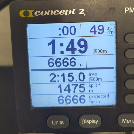 6666 Meter auf dem SkiErg – der Schweiß lügt nicht! Nahaufnahme eines SkiErg-Trainingsmonitors. Der Bildschirm zeigt eine Distanz von 6666 Metern, eine Durchschnittszeit von 2:15 pro 500 Meter und eine Zeit von 1:49 pro 500 Meter an.