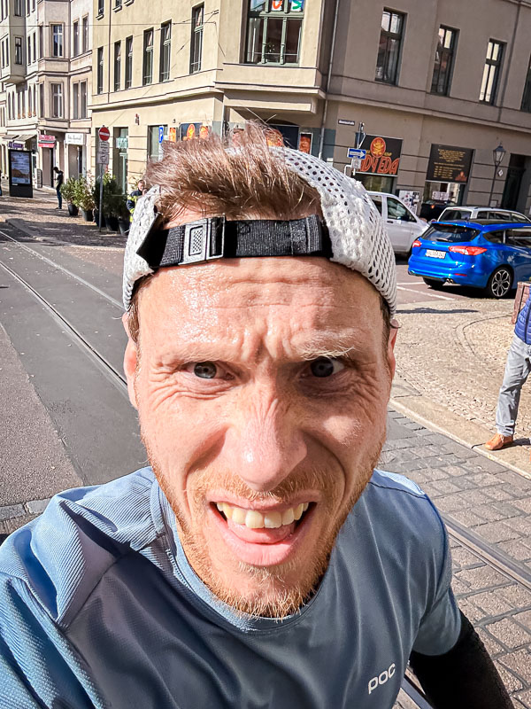 An exhausted runner pushes through the final kilometers of a half marathon. Despite fatigue, he's determined to finish the race, even though his personal best seems out of reach.