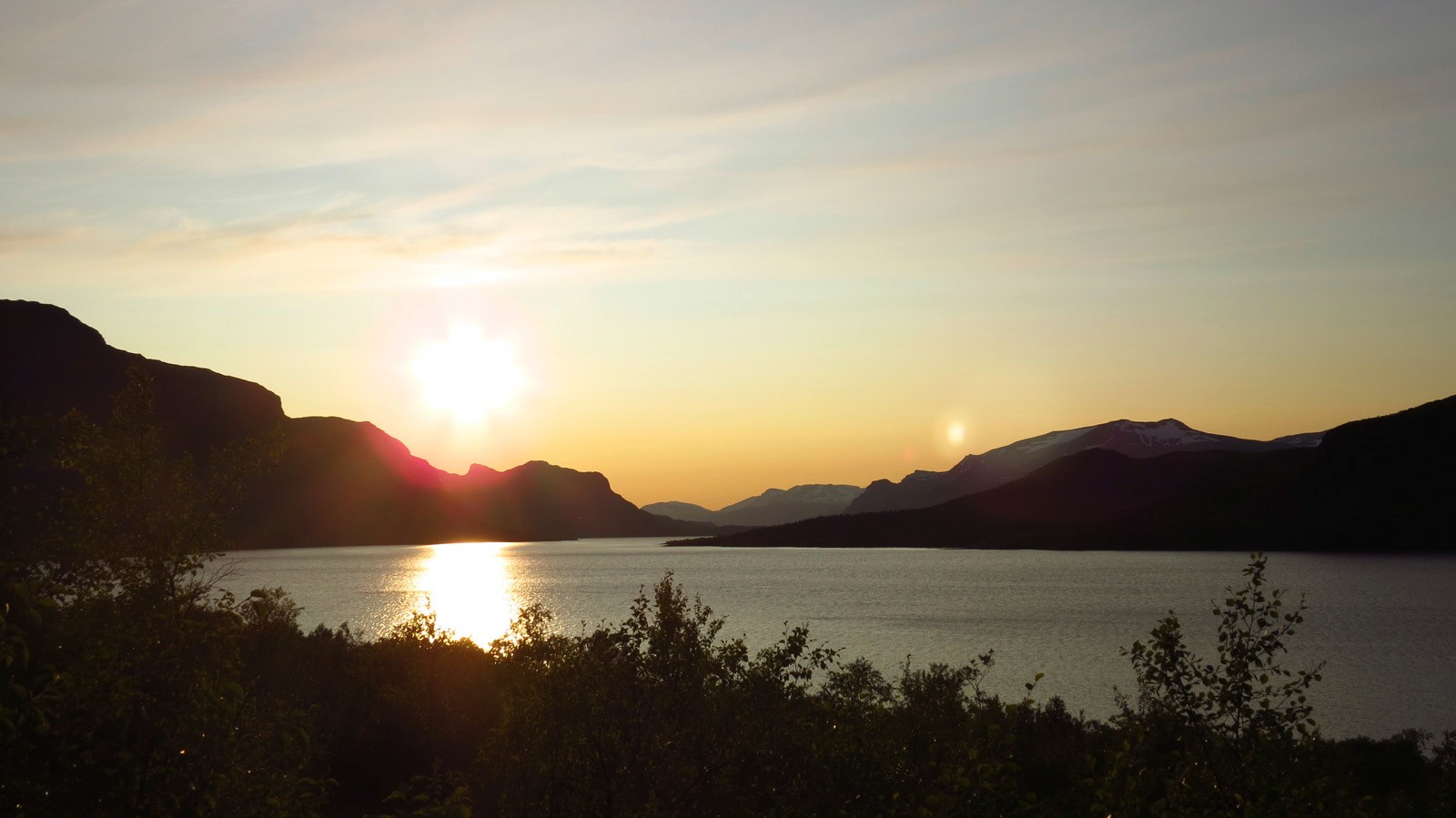 Panorama of a lake with mountains at sunset